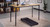 Warm wood tones and architectural black accents meet, creating a sophisticated environment designed for both productivity and movement
