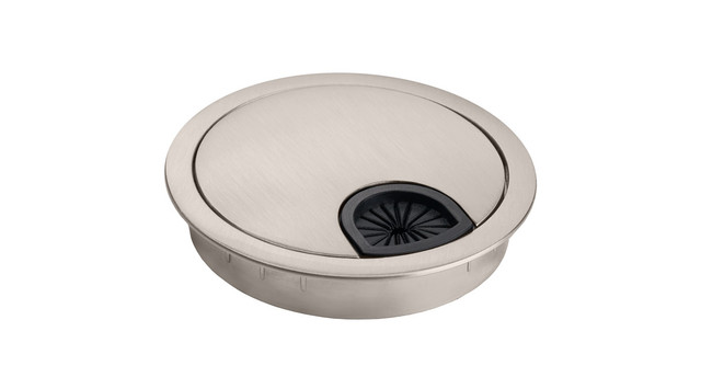 Brushed metal circular floor outlet cover with a black starburst drain visible in one side.