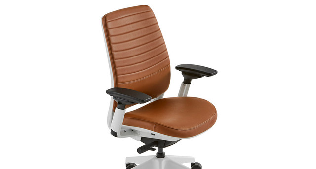 Side view of brown leather ergonomic office chair showing armrests and base.