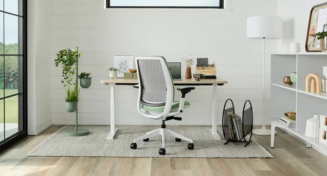 Three office chairs: brown leather executive chair, blue chair, and black mesh chair.
