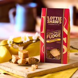 Lottie Shaw’s Classic English Salted Caramel Fudge in gift box with fudge pieces on rustic wooden board, styled with spring flowers