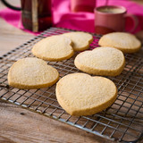 Freshly baked heart biscuits on cooling rack