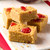 Cherry and almond flapjack squares on a wooden board