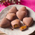 Heart-shaped milk chocolates with caramel filling on a white plate