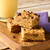 Chunky chocolate chip flapjack bars on wooden board with a glass of milk