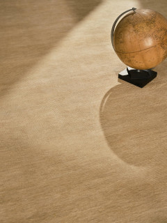 Caliche Silk rug in Dawn, styled vignette with a vintage globe