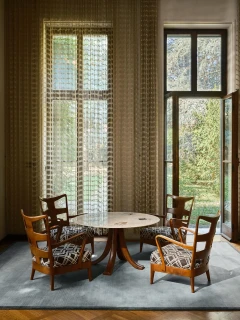 The Rug Company Margo rug, Lake colourway, styled in a dining nook with a round marble table and garden view