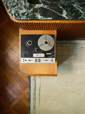 Arc rug in Spruce, corner detail beside a vintage reel-to-reel player