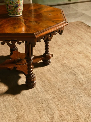 Caliche Silk rug in Olive, styled vignette with an antique side table