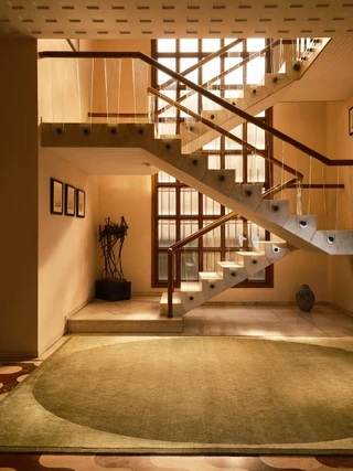 The Rug Company Doma rug, Forest colourway, styled at the base of a dramatic staircase landing