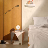 A Vitra Prismatic Coffee Table by a bed
