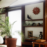 The Vitra Nelson Fan clock on a wall above a set of shelves