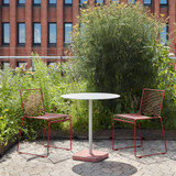 Two HAY Hee Outdoor Dining Chairs next to a table on a patio