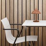 Mater Terra Portable Lamp in Coffee Rust Red on a white table Mater Terra Portable Lamp in Coffee Rust Red on a white table