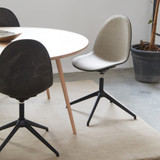 Upholstered Mater Eternity Swivel Chair next to a table