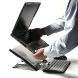 A person putting a laptop onto a Bakker Elkhuizen FlexTop 170 Laptop Stand