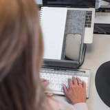 A person using a grey Bakker Ekhuizen Ergo-Top 320 Circular Laptop Stand