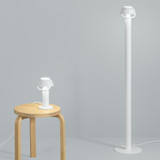 A white Artek Kori Floor Lamp next to a wooden stool with a white Kori Table Lamp