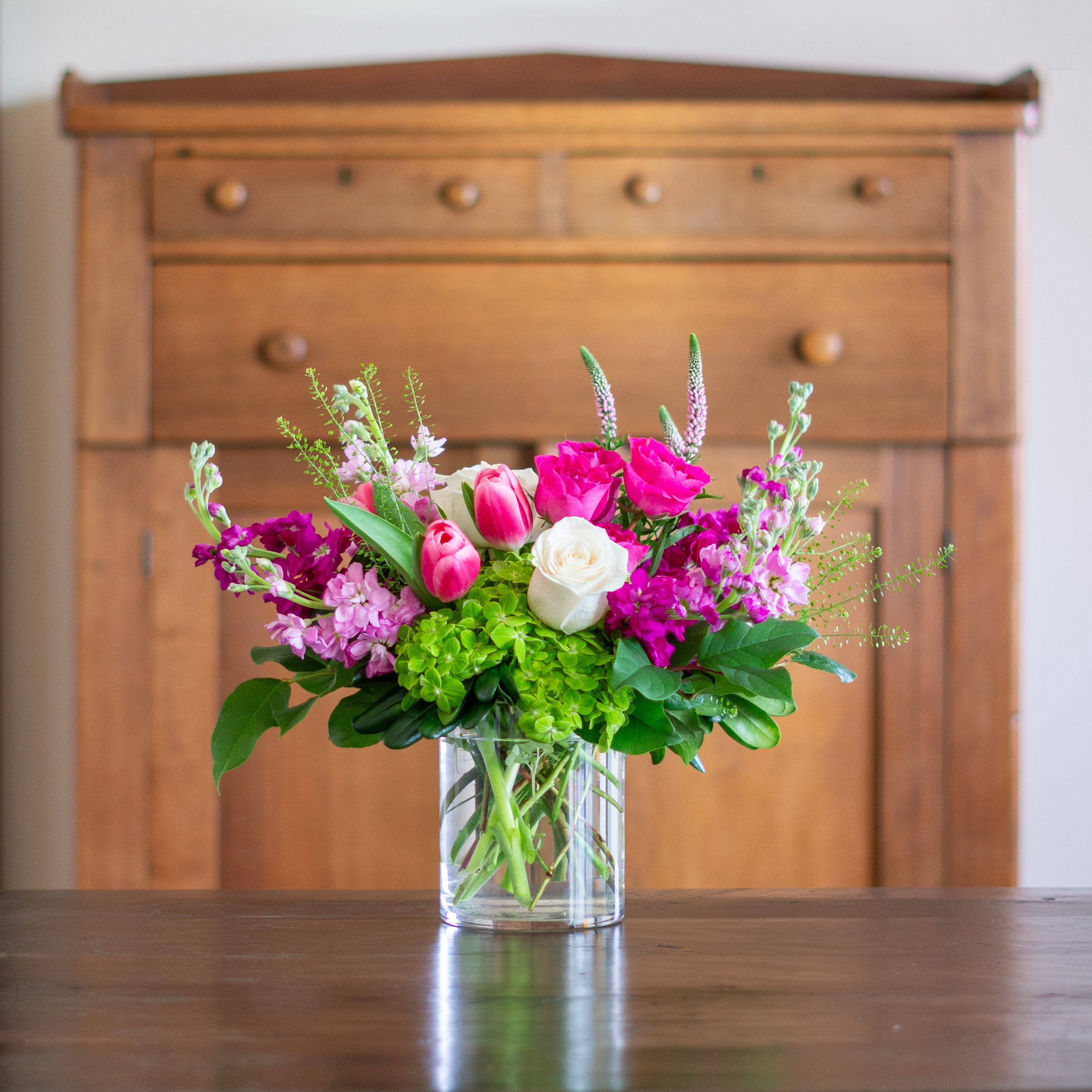 Large Valentines Day flowers for delivery to Charlotte, NC. Image shows a large garden style arrangement of peach roses, peach stock, white hydrangea, cream lisianthus, pink hypericum berries, and pink spray roses accented with spiral eucalyptus and gunni. 