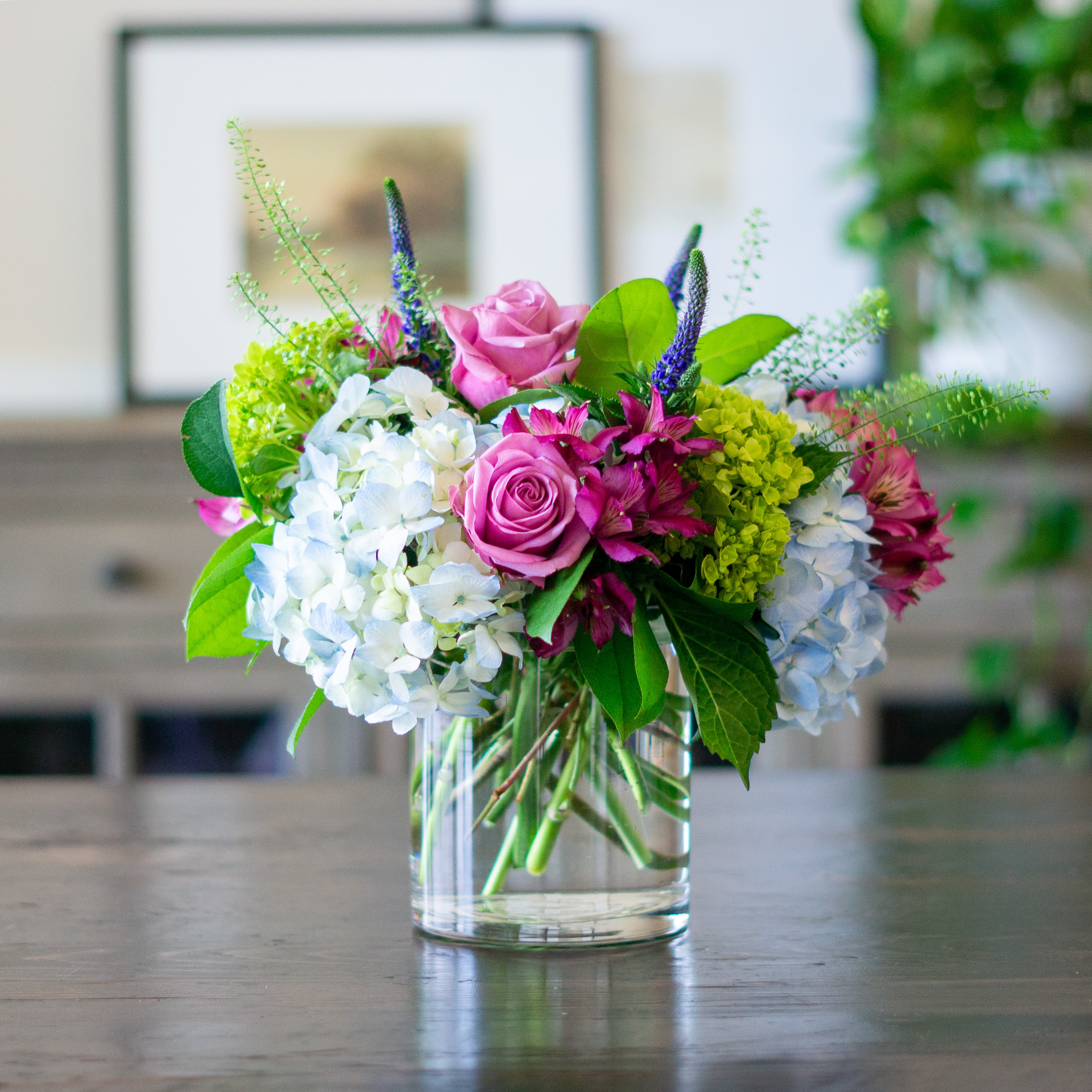 Large Valentines Day flowers for delivery to Charlotte, NC. Image shows a large garden style arrangement of peach roses, peach stock, white hydrangea, cream lisianthus, pink hypericum berries, and pink spray roses accented with spiral eucalyptus and gunni. 