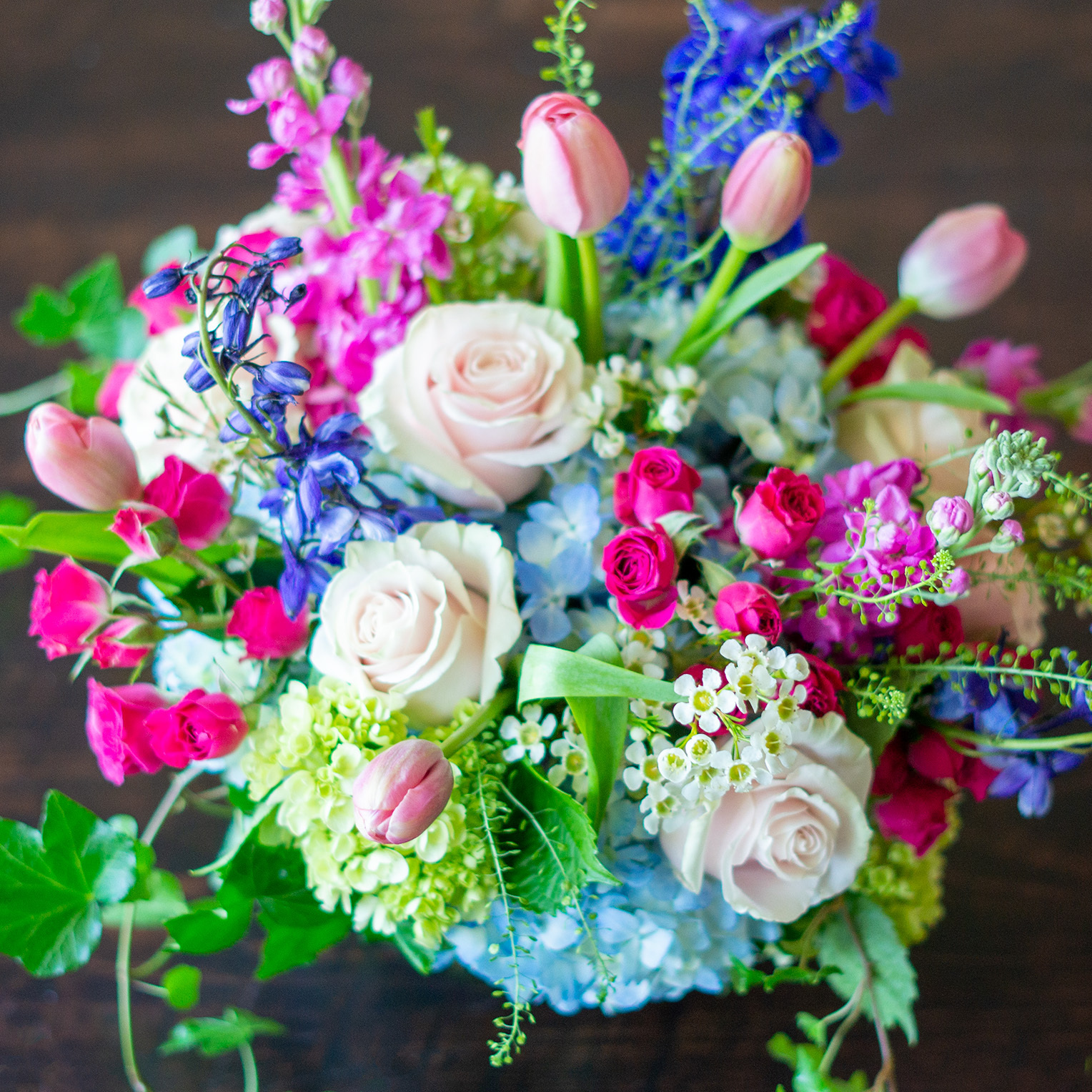 Large Valentines Day flowers for delivery to Charlotte, NC. Image shows a large garden style arrangement of peach roses, peach stock, white hydrangea, cream lisianthus, pink hypericum berries, and pink spray roses accented with spiral eucalyptus and gunni. 