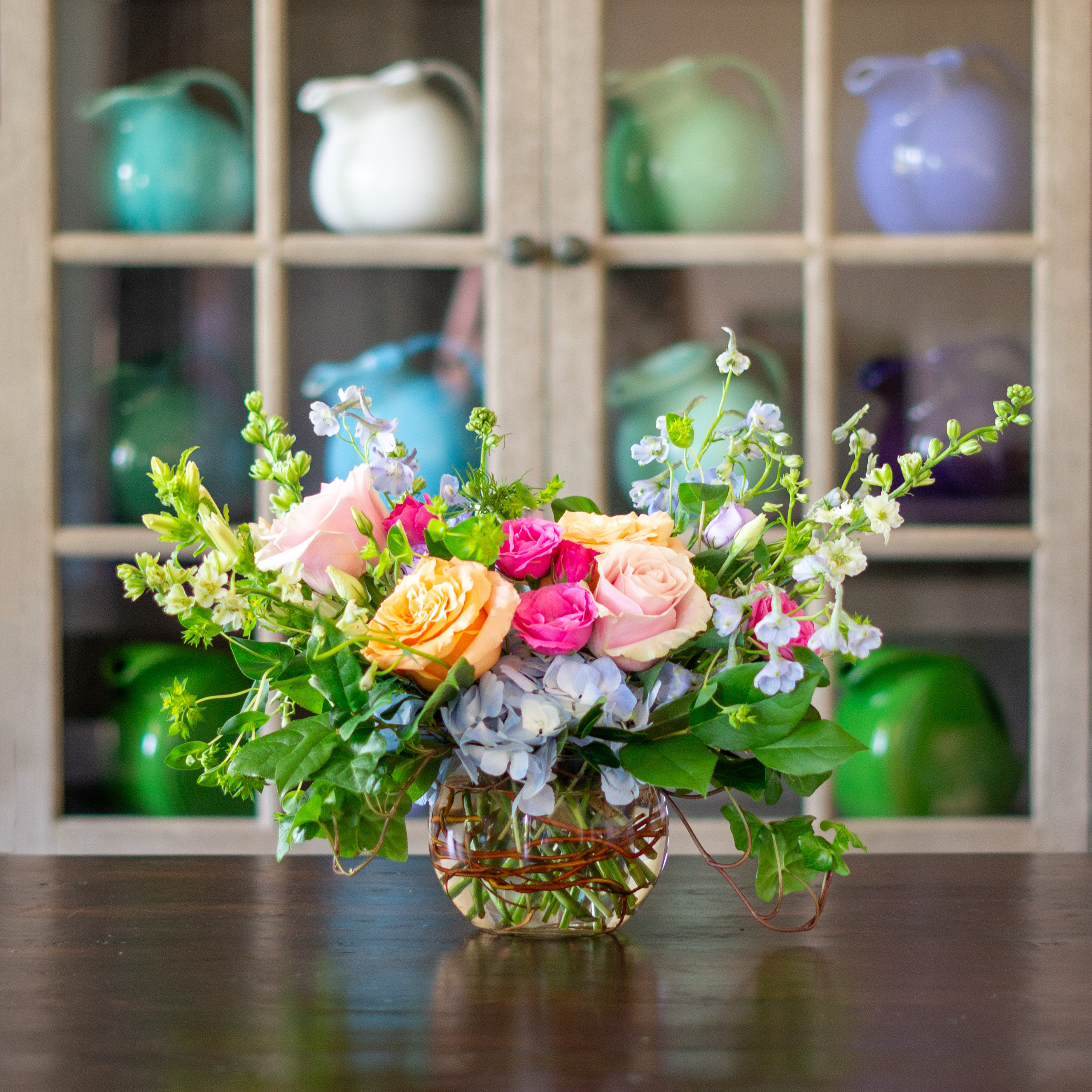 Peach valentines day flower arrangement for delivery to Charlotte NC. Image is a closeup of a pink rose with a peach center surrounded by peach stock and pink majolika spray roses. 
