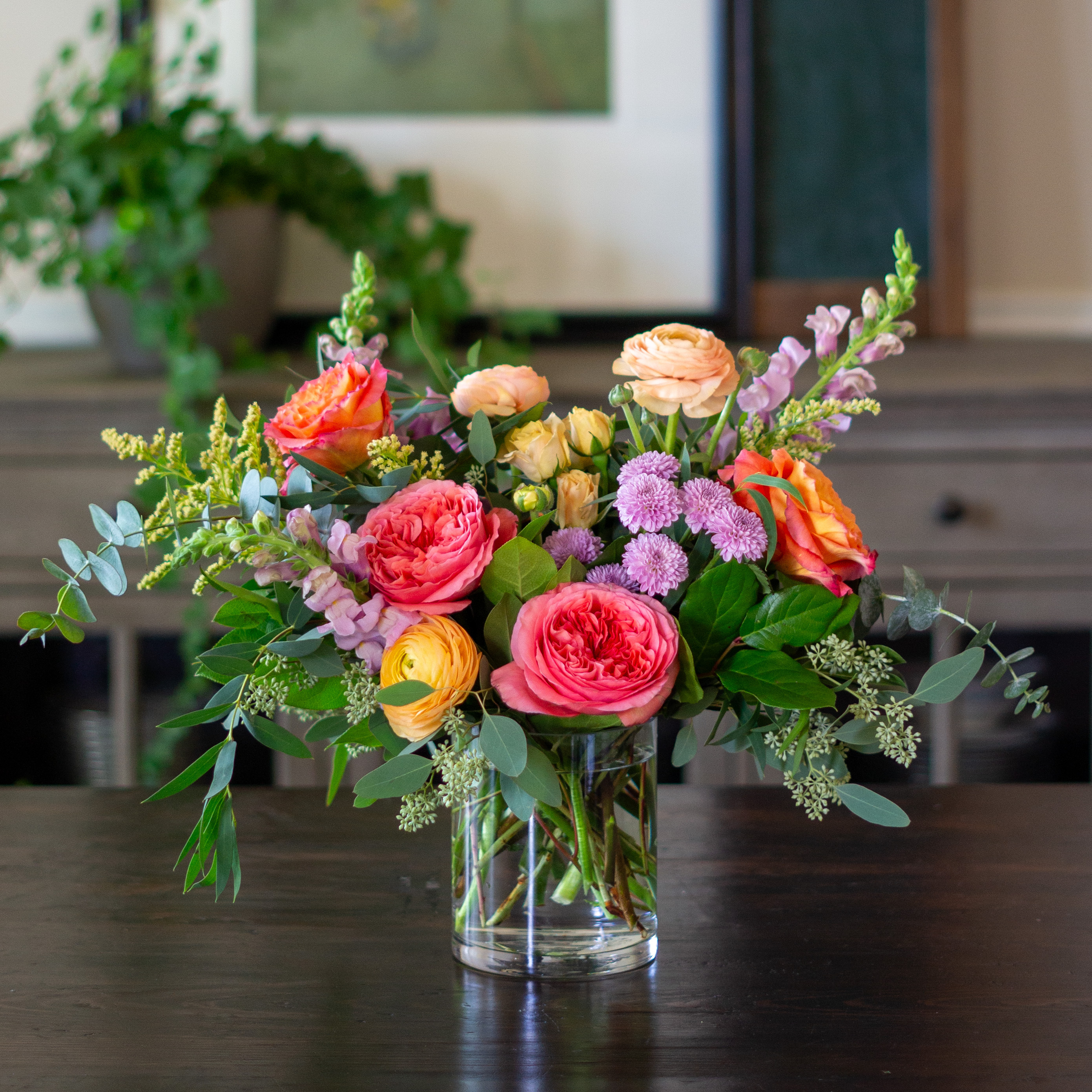 Top down view of a Nightingale's valentine's day roses - image shows a perfect three dozen red roses arranged in a Charlotte vase and sitting on a black table with a white background.  