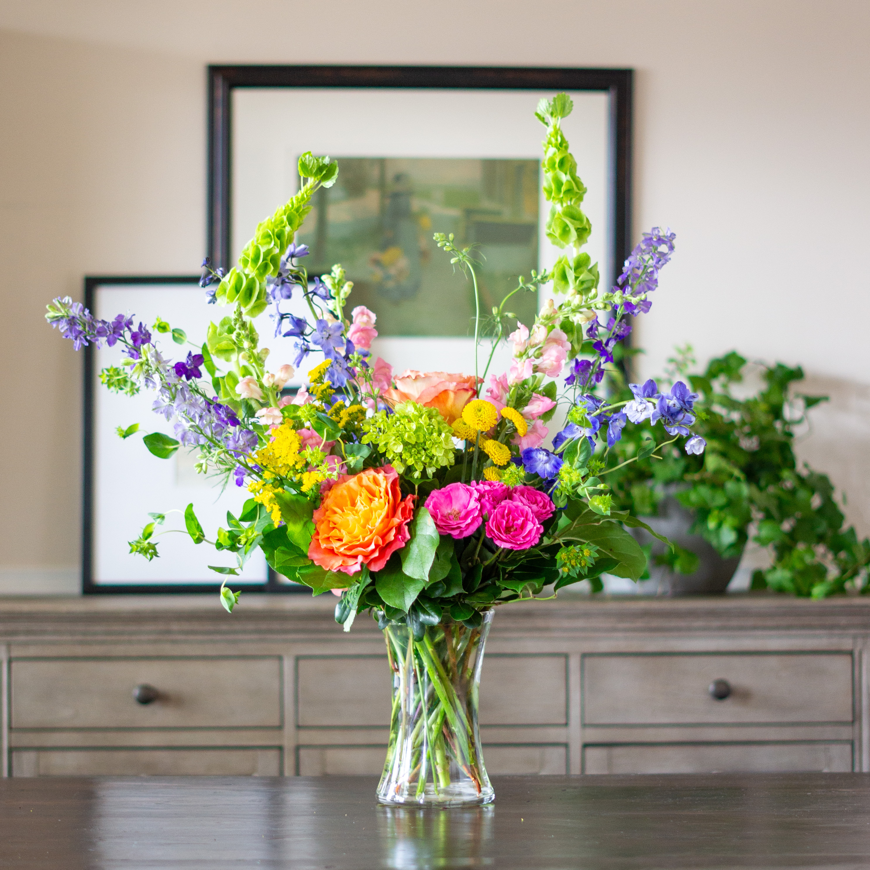 Top down view of a Nightingale's valentine's day roses - image shows a perfect three dozen red roses arranged in a Charlotte vase and sitting on a black table with a white background.  