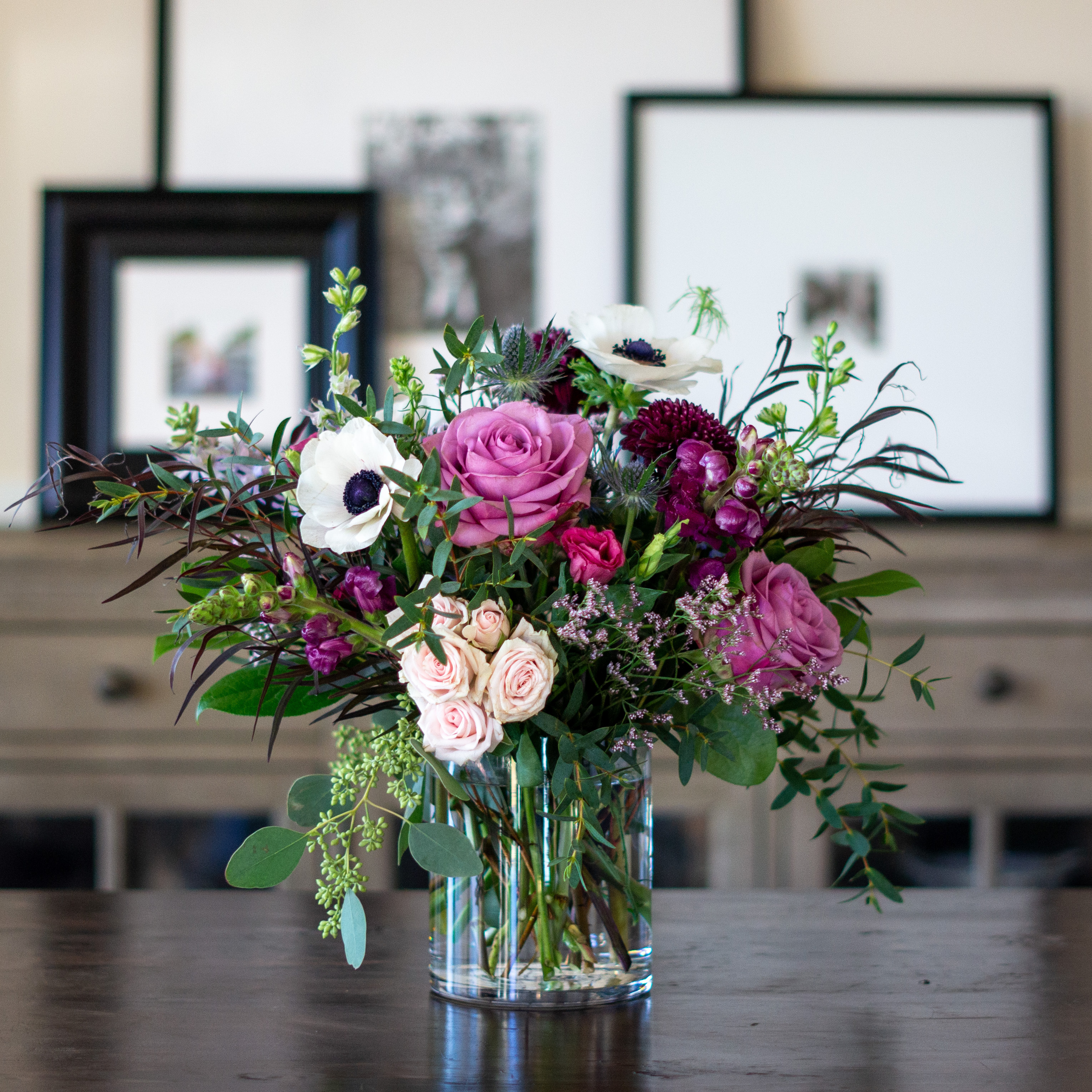 Top down view of a Nightingale's valentine's day roses - image shows a perfect three dozen red roses arranged in a Charlotte vase and sitting on a black table with a white background.  
