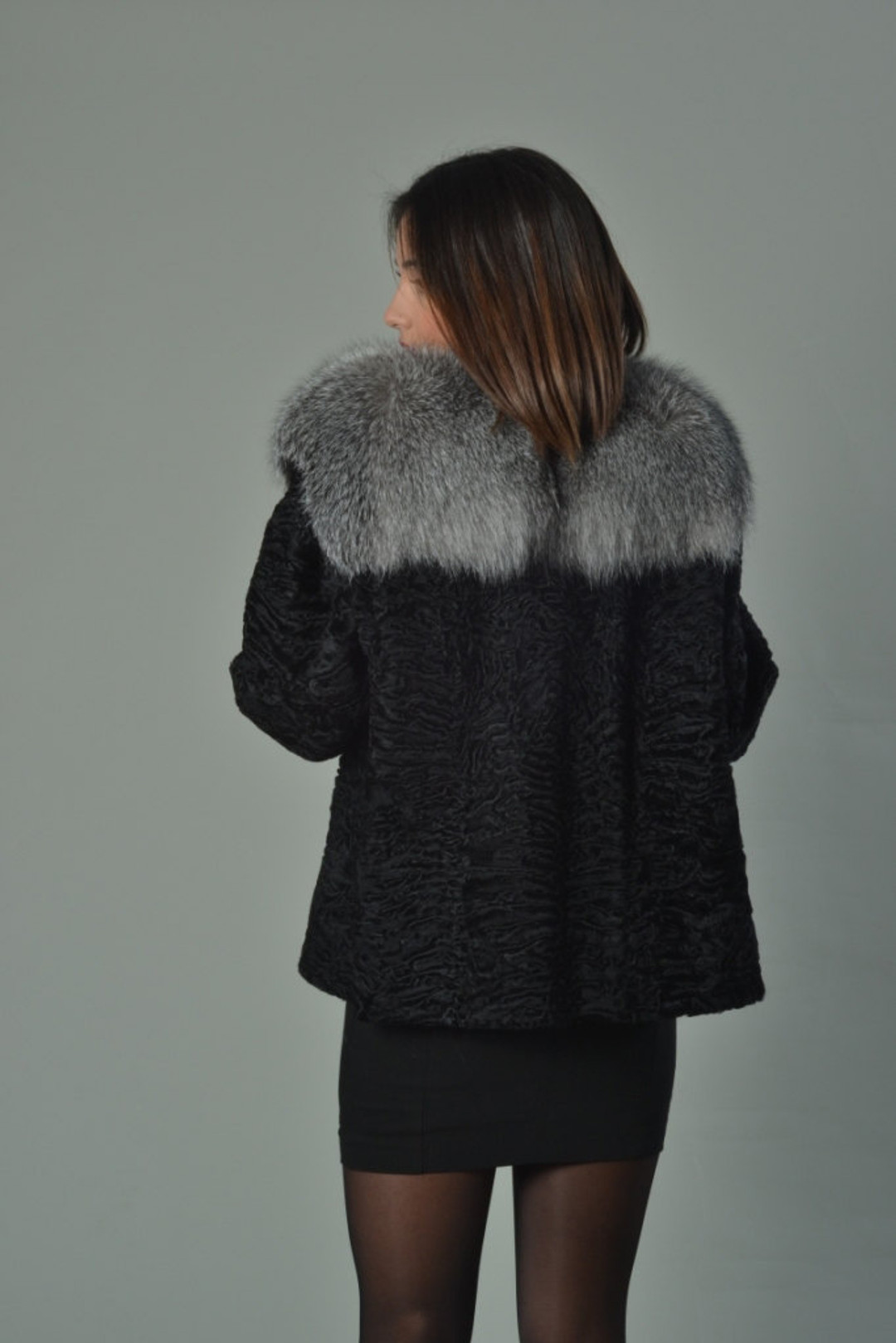 Black Persian Lamb Fur Jacket with Fox Collar on model rear view Black Persian Lamb Fur Jacket with Fox Collar on model rear view