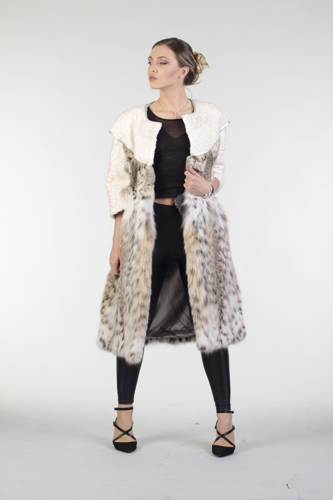 lynx fur coat with white swakara fur , unfastened showing the wide bottom sweep of the fur coat