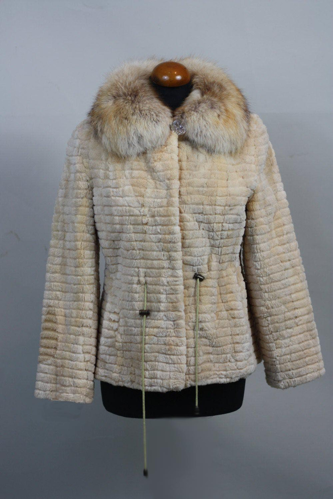 cream ssheared and sculpted beaver fur jacket with fox collar and drawstrings on mannequin