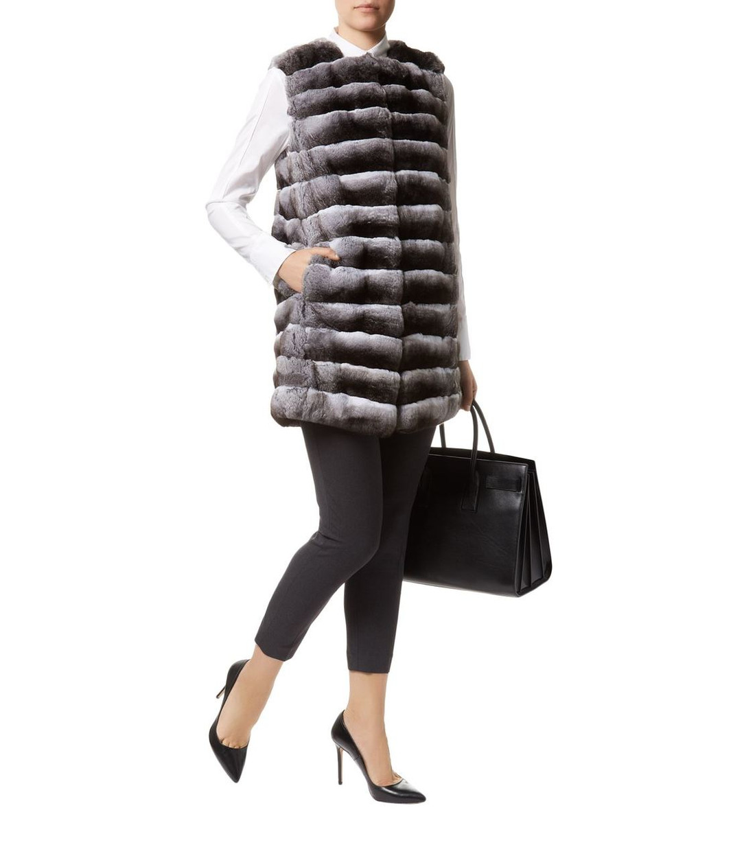 Long Chinchilla Fur Vest on Model wearing white woolen blouse , black tight pants , black heels and black leather bag with handle