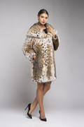 hooded lynx fur coat , knee length on brown haired model with french twist , collarless black blouse and black mini  skirt