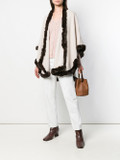 off white cahsmere wool cape with brown rex fur trim o nmodel wearing salmon shirt , white cotton pants , tan leather bag and brown leather boots off white cahsmere wool cape with brown rex fur trim o nmodel wearing salmon shirt , white cotton pants , tan leather bag and brown leather boots