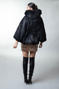 black astrakhan cape hooded with fox trim leather belt on model rear view black astrakhan cape hooded with fox trim leather belt on model rear view