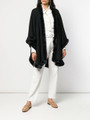 black cashmere cape with rex fur trim on model wearing white shirt and linen pants and beige flat shoes