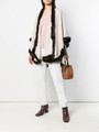 off white cahsmere wool cape with brown rex fur trim o nmodel wearing salmon shirt , white cotton pants , tan leather bag and brown leather boots