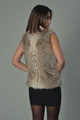 ynx fur vest with short stand up collar on brunette model  with black mini dress and short black straight hair rear view