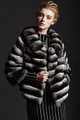 chinchilla fur coat waist length , round collar , cropped sleeves on model matched with black and white dress