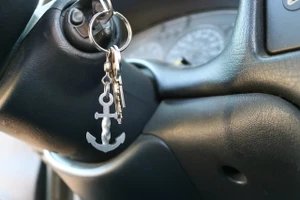 Twisted Anchor stainless steel keychain tool hanging from car keys in an ignition, showing everyday carry use.
