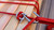 Unreasonable Shackle securing wood with red paracord, showing tight adjustable tie-down connection.