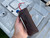 Hand holding a leather firecracker-style paracord dispenser with red 550 cord exiting the top, showing compact size and portability.