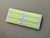 Angled view of a sheet of oval glow-in-the-dark stickers on a white backing.