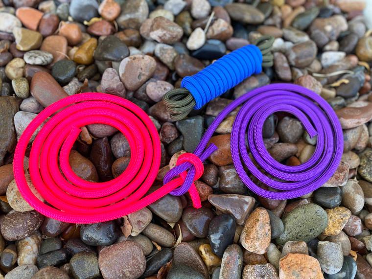 Multiple colors of Paramax practice rope coils on rocks, showing thick cord for knot training.