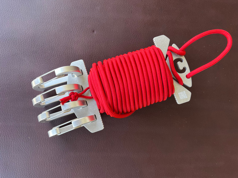 Red paracord wrapped around a spool with 4 carabiners attached.