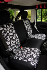 Hawaiian seat covers on Jeep rear bench, black and white hibiscus pattern with solid black center panels and headrests.