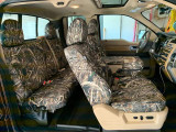 Side profile of a crew cab truck interior with custom-fit Realtree Camo seat covers installed on both rows, highlighting a seamless and tailored fit.