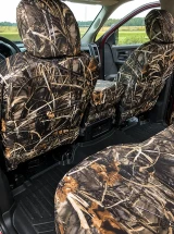 Rear view of front truck seats with Realtree Waterproof Camo covers, showing the precise fit and integrated storage pockets on the seat backs.