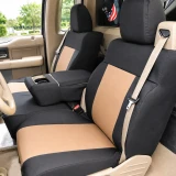 Atomic Pro-Tect seat covers on truck 40/20/40 bench, black bolsters with tan center panels and cupholder cutout on armrest.